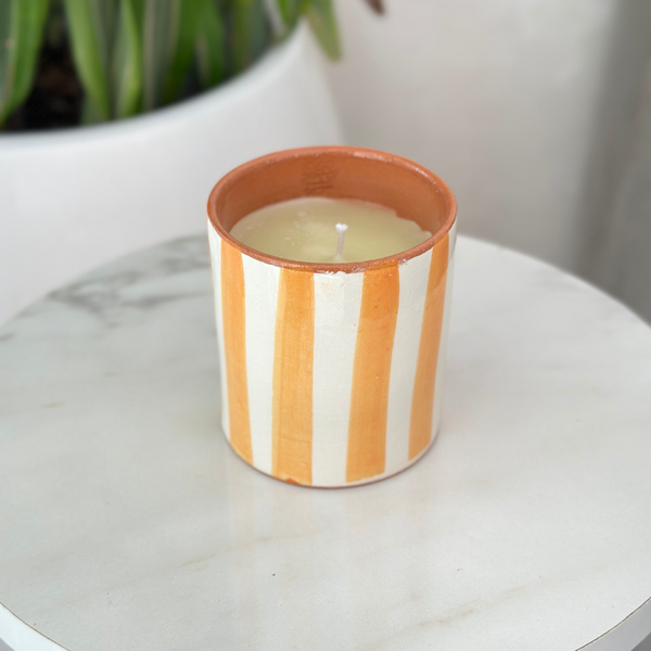 Bougie artisanale rayée orange clair en terre cuite parfum Ambre