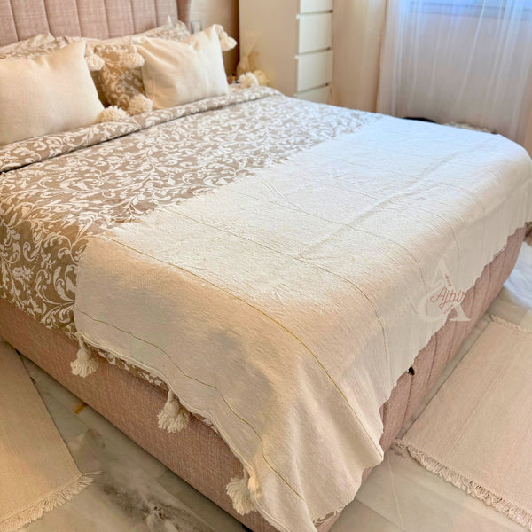 Plaid artisanal à pompons blanc liseré doré 90cm/180cm