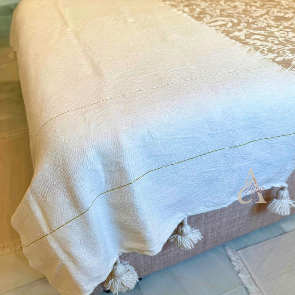 Plaid artisanal à pompons blanc liseré doré 90cm/180cm