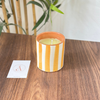 Bougie artisanale rayée orange clair en terre cuite parfum Ambre