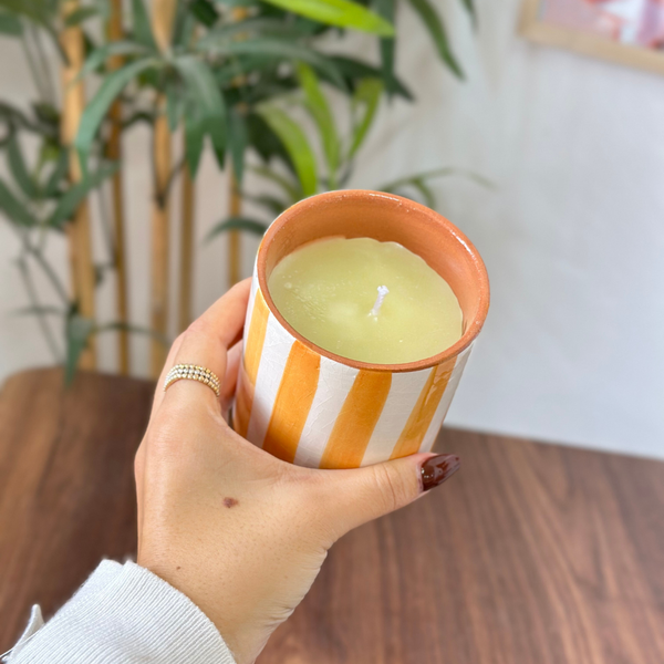Bougie artisanale rayée orange clair en terre cuite parfum Ambre