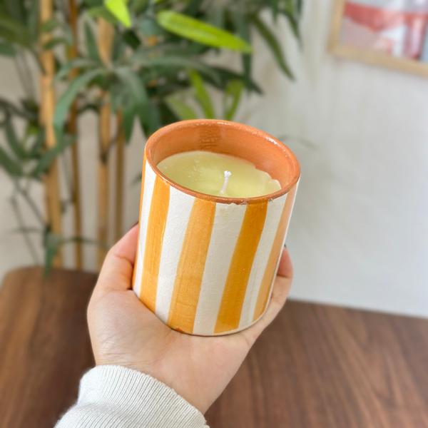 Bougie artisanale rayée orange clair en terre cuite parfum Ambre