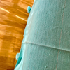 Plaid artisanal à pompons turquoise liseré argenté 2,80m x 2,00m