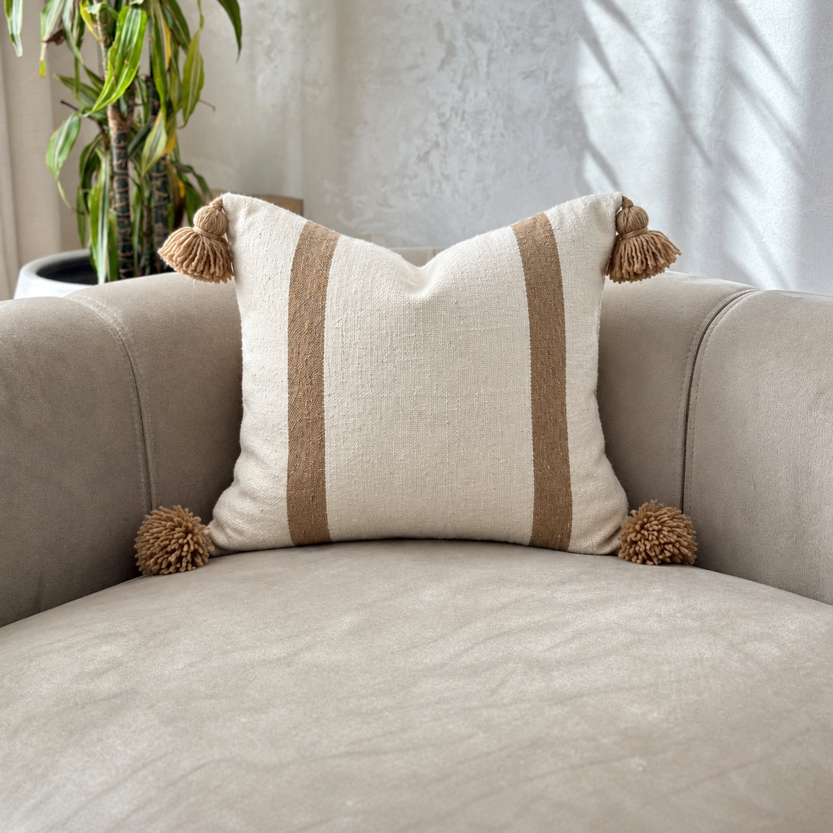 Housse de coussin artisanale à pompons rayée en blanc et beige